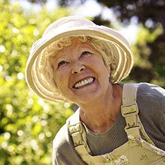 Senior woman in sun hat with dentures smiling