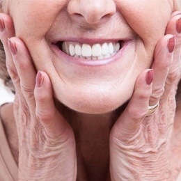 Woman showing off her implant retained dentures