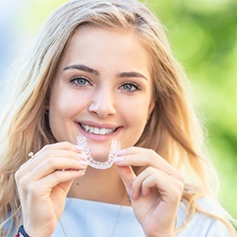 Wearing your aligners:young woman holding Invisalign aligner