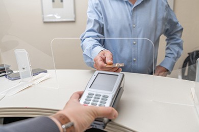 A man using a credit card to pay for his dental care