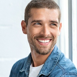 A young man with a beard smiling after cosmetic dentistry