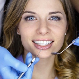 A young woman having her teeth checked after porcelain veneer treatment