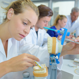 A lab technician working on a set of dentures