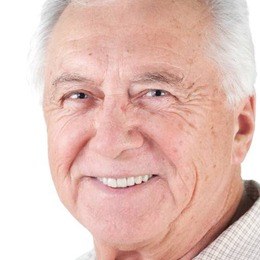 Smiling older man with a dental implant retained denture