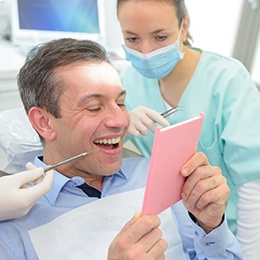 Man admiring his smile while at dental office