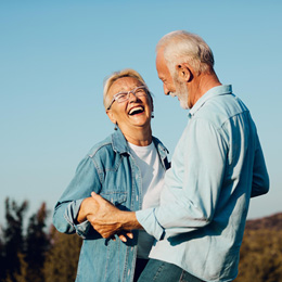 Older couple laughing and smiling after using their dental insurance in Arlington 