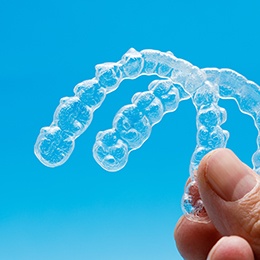 person holding clear aligners