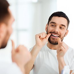 closeup of man flossing his teeth 