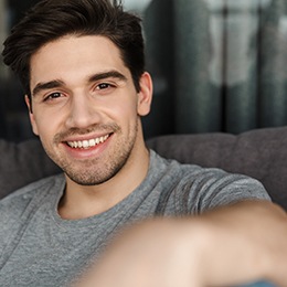 man smiling while sitting on couch 