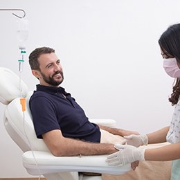 A dentist preparing a man for IV sedation