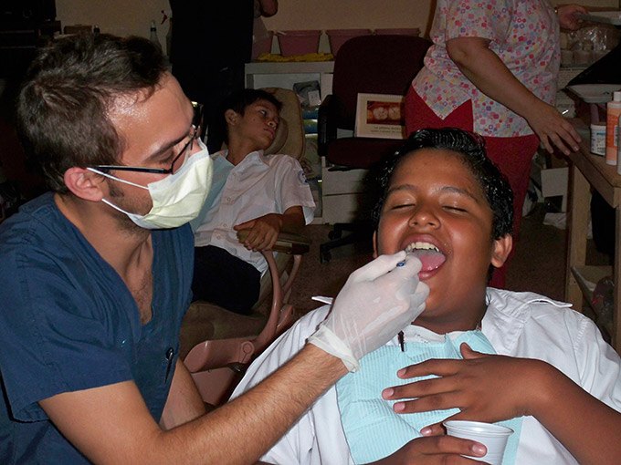 Dr. Douglas Baldwin performing dentistry on boy