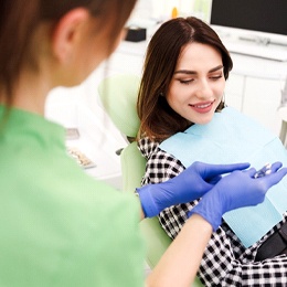 A dentist showing a female patient the shade of her new porcelain veneers