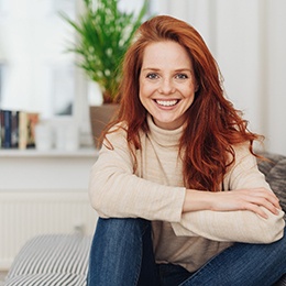 woman smiling while sitting on couch 