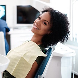 A young female sits in the dentist’s chair waiting to learn if she’s eligible for teeth whitening in Arlington