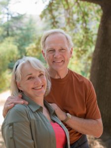 Senior couple smiling with secure dentures thanks to the dental implants arlington patients love