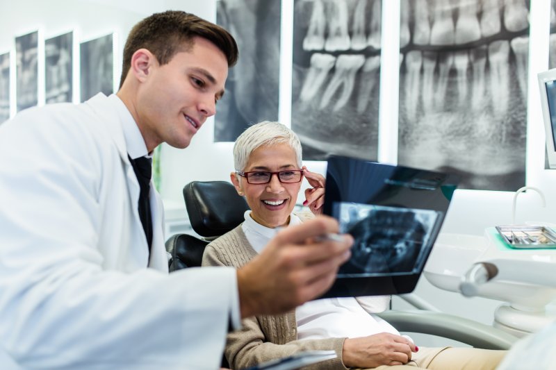 an older woman reviewing a dental X-ray with her dentist