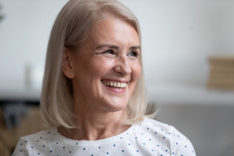 an older woman smiling with her new dental implants