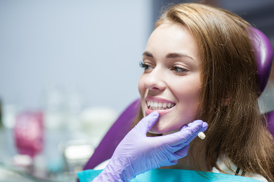 woman smiling while visiting cosmetic dentist 