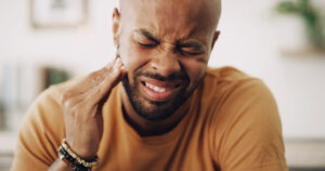 patient holding jaw while in pain