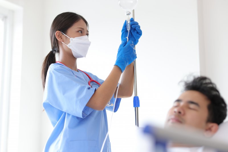 dental assistant setting up an IV for her patient