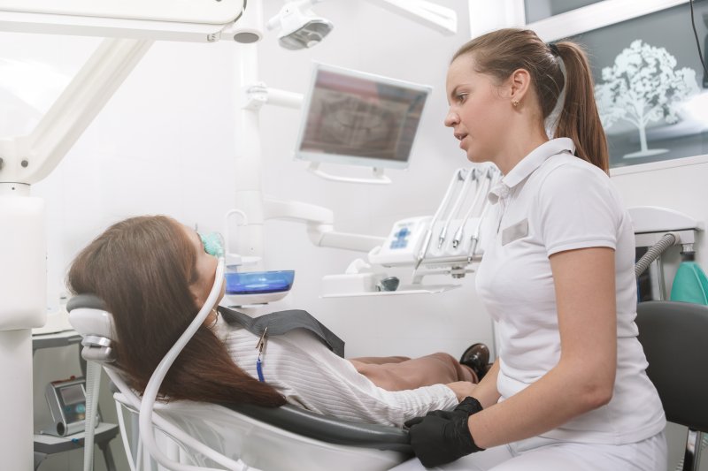 A patient talking to her dentist while wearing a sedation mask